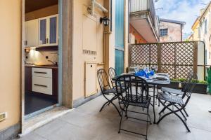 a patio with a table and chairs on a balcony at Hostdomus - Salsedine Apartment in Alassio