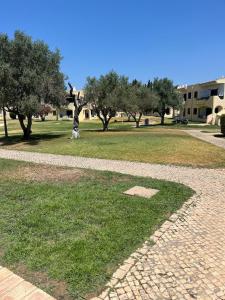 a park with a statue in the grass and trees at Casa das Oliveirinhas in Alvor