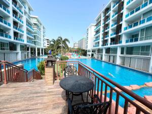 a balcony with a table and chairs next to a swimming pool at My Resort Condo in Hua Hin E204 in Hua Hin