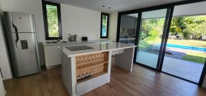 a kitchen with a counter with a sink and glass doors at Casa Quinta El Rodeo in La Plata