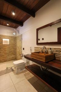 a bathroom with a sink and a toilet and a mirror at Vila Loop in São Miguel do Gostoso
