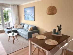 a living room with a blue couch and a table at Ferienwohnung MEERWEH in Fehmarn