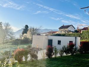 a white house in a yard with a building at Gîte neuf au calme, RDC, Terrasse, Parking, 2 chambres, Clim in Beaucroissant