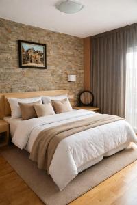 a large bed in a bedroom with a brick wall at Vestigia Nueva Castilla in Sigüenza +5 photos