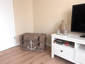 a living room with a wicker basket next to a tv at Ferienwohnung MEERWEH in Fehmarn