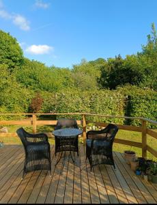 three chairs and a table on a wooden deck at Skøn rolig villa in Dianalund +8 photos