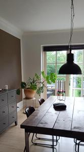 a dining room with a large wooden table and chairs at Skøn rolig villa in Dianalund