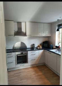 a kitchen with white cabinets and a stove top oven at Skøn rolig villa in Dianalund