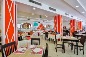 a dining room with tables and chairs in a restaurant at Ciccio Hotel in Misano Adriatico