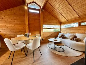 a room with a couch and a table and chairs at Chalet Ivoire in Durbuy