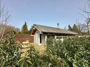 a small white house with a porch in a garden at Chalet Ivoire in Durbuy