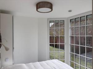 a bedroom with white walls and large windows at Ferienwohnung MEERWEH in Fehmarn