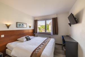 una camera d'albergo con un letto e una finestra di Hôtel Terminus a Porrentruy