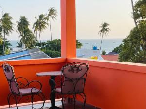 a balcony with two chairs and a table and a view of the ocean at Orange Villa Muine in Mui Ne +23 photos