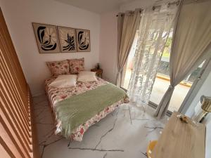 a bedroom with a bed in front of a window at Studio neuf élégant- calme & cosy in Oyonnax
