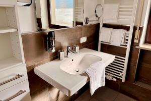 a bathroom with a white sink and a mirror at Hotel Garni Möwe in Tutzing +29 photos