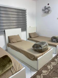 two beds in a room with at درة عبين الدور الارضي 2 in ‘Ibbīn