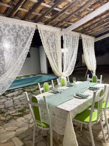 a table with green chairs and a white table cloth at Villa Bárbara residência in Aracaju