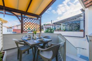a patio with a table and chairs on a balcony at Lido del Bardo in Marina di Cecina +9 photos
