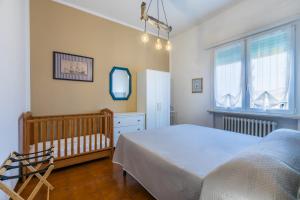 a bedroom with a bed and a crib and windows at Lido del Bardo in Marina di Cecina