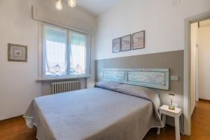a bedroom with a bed and two windows at Lido del Bardo in Marina di Cecina