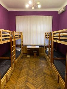 a room with three bunk beds and a purple wall at Хостел Центр in Kharkiv