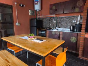 a kitchen with a wooden table and orange chairs at Departamento BenLu in Puerto Iguazú