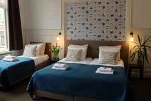 two beds in a hotel room with blue and white at Bed & Breakfast Hotel Malts in Haarlem