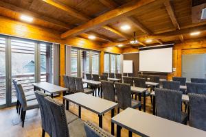 a conference room with tables and chairs and a screen at Butikhotel Visegrád in Visegrád