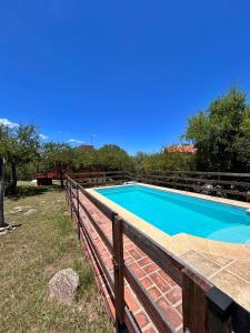 a swimming pool with a wooden fence around it at Malenka in Pantanillo