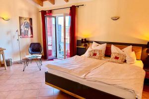 a bedroom with a large bed and a chair at Hotel Garni Möwe in Tutzing