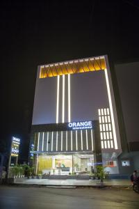 un grand bâtiment avec un panneau la nuit dans l'établissement Hotel Orange International, à Surate