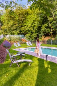 a woman is sitting next to a swimming pool at Butikhotel Visegrád in Visegrád