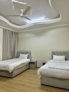 a bedroom with two beds and a ceiling at BAIT AL-AFIA Hotel in Sur