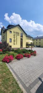 a large building with flowers in front of it at Hotel Chańcza Spa & Restauracja in Raków