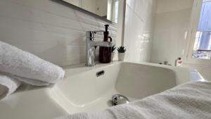 a white bathroom with a bath tub with a sink at Escapade sur la Loire in Nevers