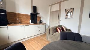 a living room with a couch and a kitchen at Escapade sur la Loire in Nevers