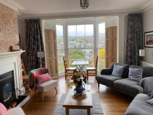 a living room with a couch and a fireplace at Bryn Mair Gardens in Dolgellau