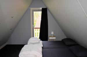 a bedroom with a bed and a window at Torenvalk I Genieten nabij Bos in Zwiggelte +10 photos