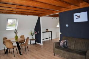 a living room with a couch and a table at Torenvalk I Genieten nabij Bos in Zwiggelte