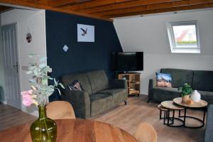a living room with two couches and a table at Torenvalk I Genieten nabij Bos in Zwiggelte