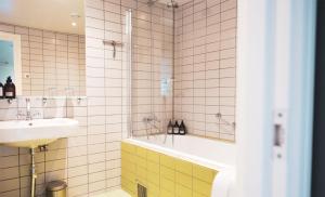 a bathroom with a tub and a sink and a shower at Hotell Borgholm in Borgholm +69 photos