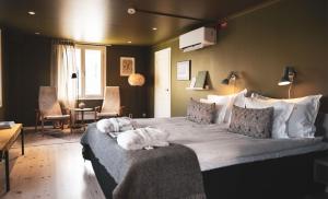 a bedroom with a large bed with two cats laying on it at Hotell Borgholm in Borgholm