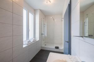 un bagno bianco con doccia e lavandino di Hôtel Terminus a Porrentruy Altre 53 foto