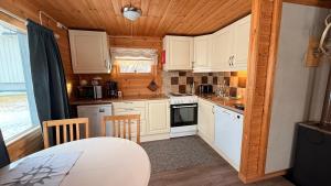 a small kitchen with white cabinets and a table at Bringnes Camp in Russenes