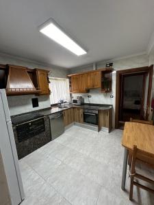 an empty kitchen with wooden cabinets and a table at Casa en Laredo in Laredo +9 photos