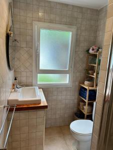 a bathroom with a sink and a window and a toilet at Casa en Laredo in Laredo