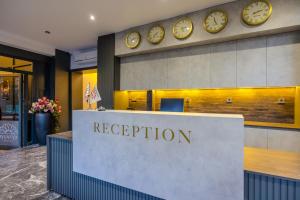 a reception desk with clocks on the wall at Ayçiçeği Comfort Otel in Edirne