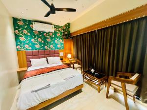 a bedroom with a bed and a wall with flowers at Hotel ShivSundar Executive in Aurangabad