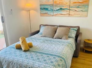a teddy bear sitting on top of a bed at Sunrise Beach Hideaway in Exmouth